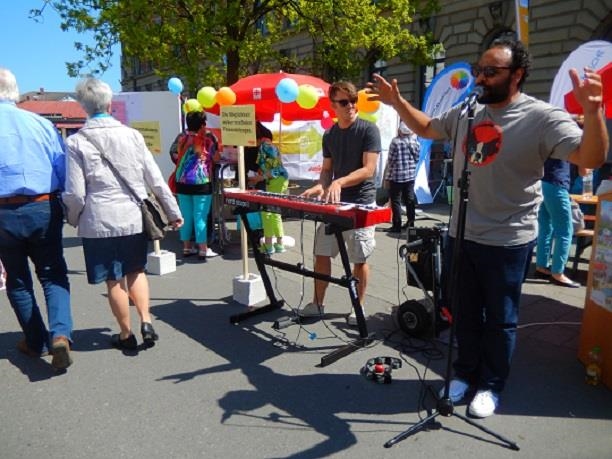 Sänger mit Keyboarder vor einer Menschenmenge (Caritas Konstanz)