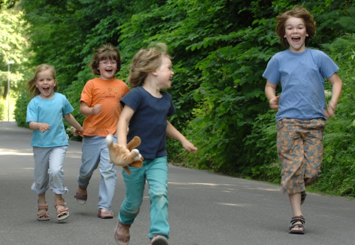 vier rennende Kinder mit freudigem Gesicht