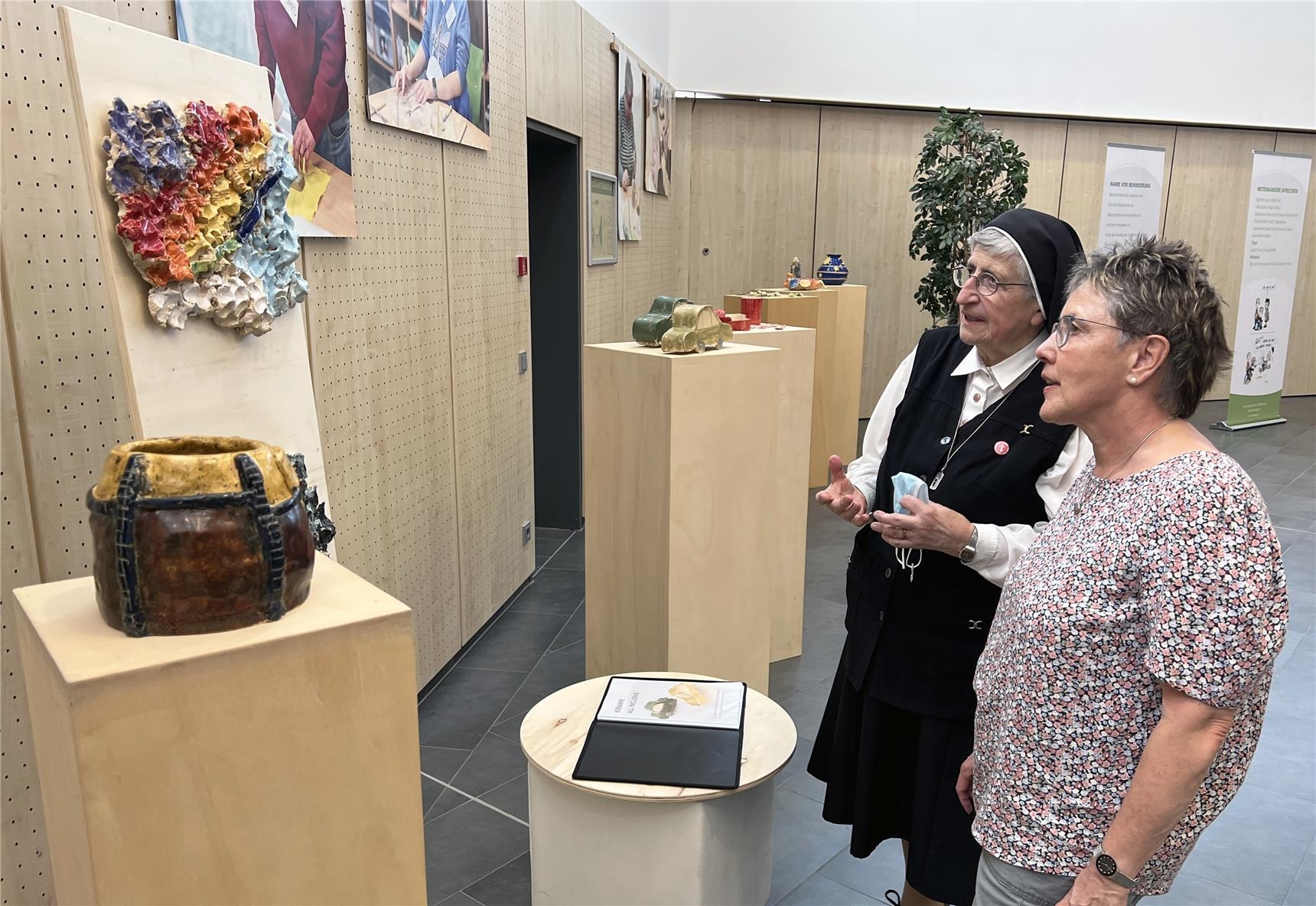 Zwei Gäste schauen sich die Ausstellung ind er Stadthalle an. (Caritasverband Westerwald-Rhein-Lahn e.V. / Holger Pöritzsch)