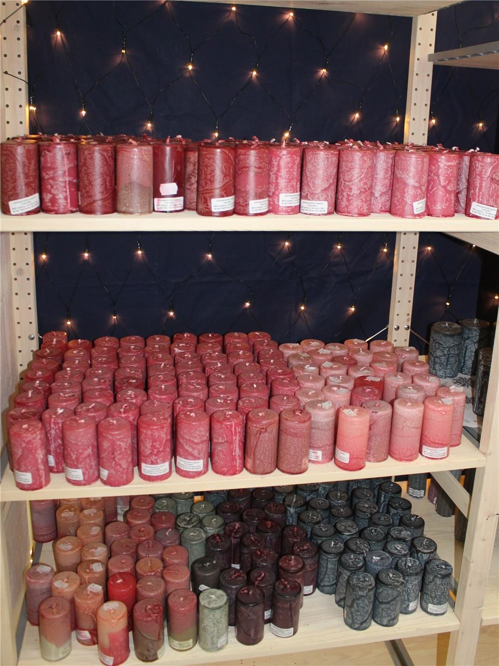 Viele bunte Kerzen in einem Regal (Lisa Schreiber)