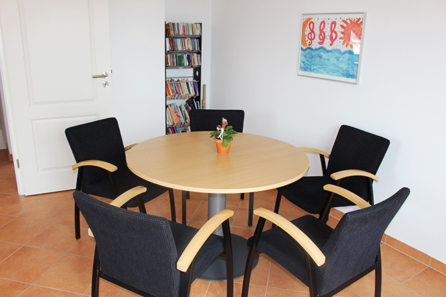 Raum mit rundem Tisch und fünf Stühlen daran (Caritasverband Darmstadt e. V.)