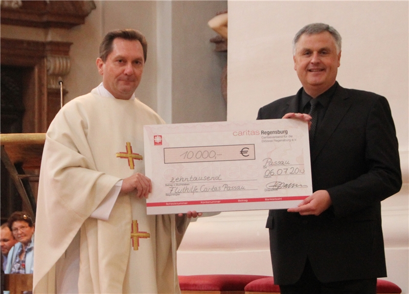 Vor dem Gottesdienst im Dom St. Stephan überreichte Diözesan-Caritasdirektor Dr. Roland Batz (li.) einen Scheck mit 10 000 Euro für die Hochwasseropfer an den Passauer Bischöflichen Caritas-Beauftragt (burcom Regensburg)