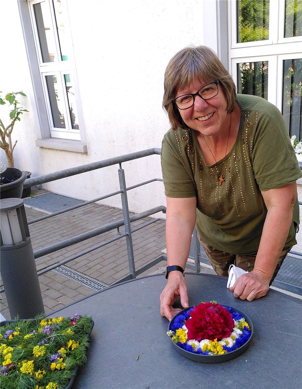 Seelsorgerin Frau Gardt bei der Vorbereitung des Blumenschmucks für das Fronleichnamsfest (© Caritasverband Worms e. V.)