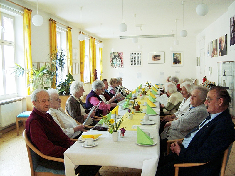 Bewohnerinnen und Bewohner beim frühlingsfrischen Osterfrühstück in gelb-grün- 