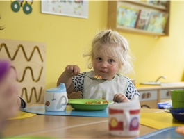 Ein Mädchen sitzt am Tisch und isst Möhrensuppe zu Mittag / Dietmar Wäsche