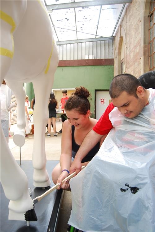 Mädchen unterstützt Rollstuhlfahrer beim Malen (Caritas Speyer)