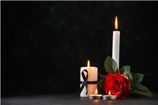 front-view-of-burning-candles-with-red-flower-on-dark-surface
