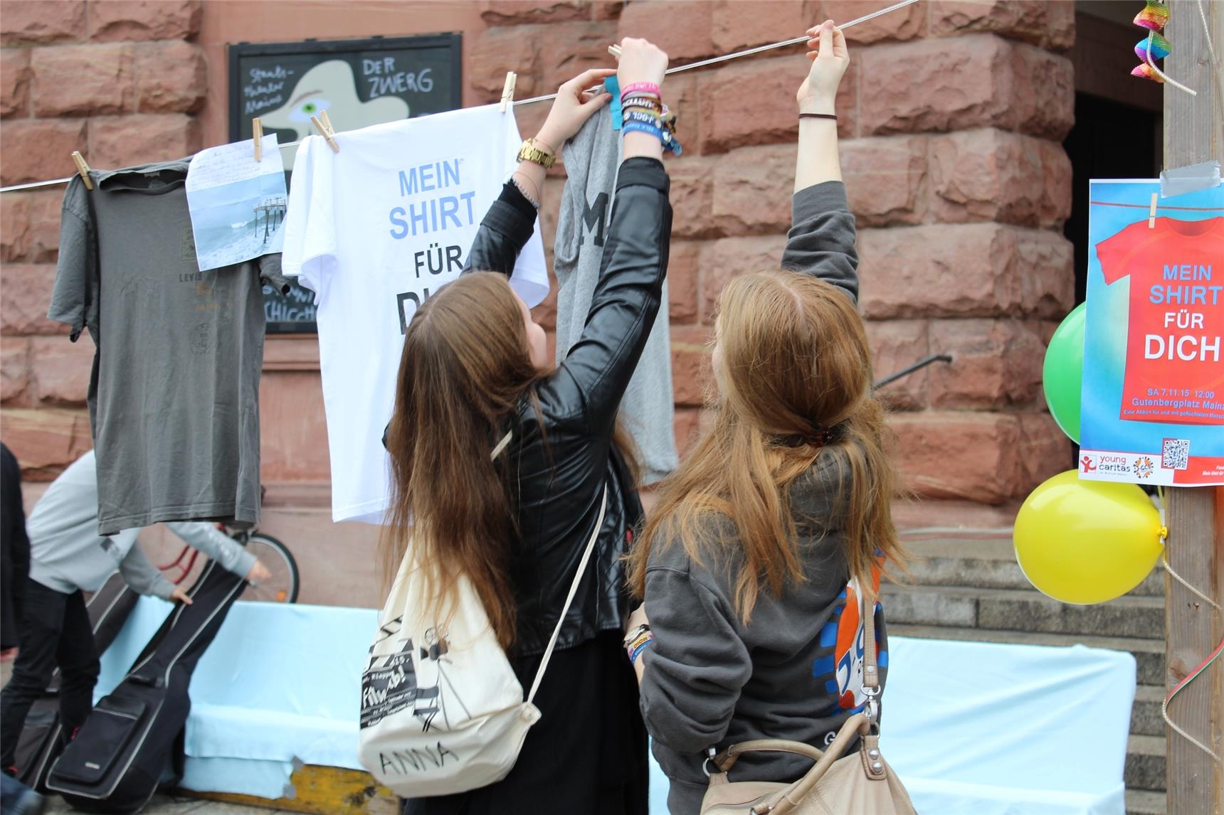 Zwei Mädchen hängen ein T-Shirt auf (youngcaritas im Bistum Mainz)
