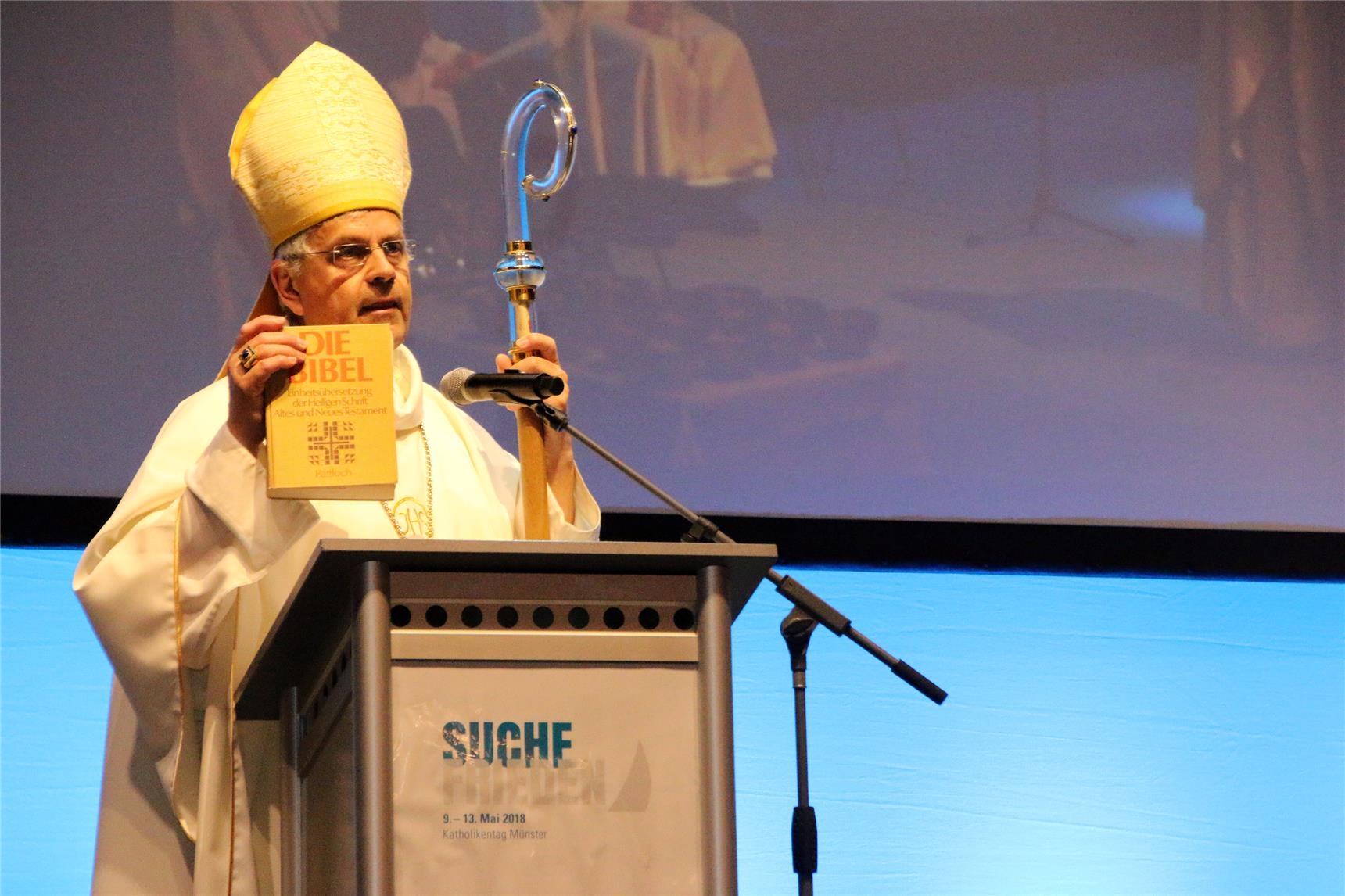 Das Foto zeigt einen Bischof am Ambo mit Bibel in der Hand. (Harald Westbeld)