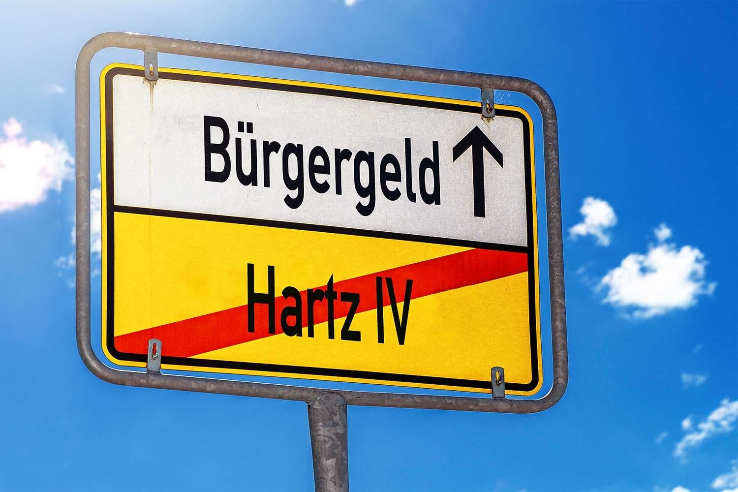 Ortsausgangsschild mit der Aufschrift Hartz 4 und Bürgergeld. Hartz 4 ist durchgestrichen.