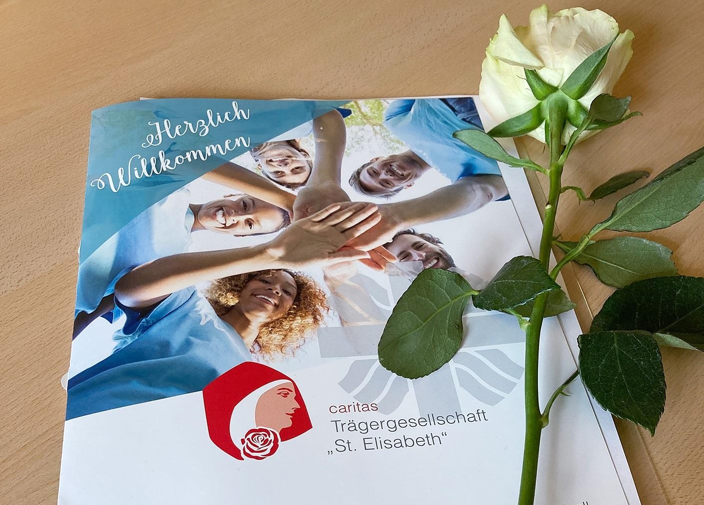 Begrüßungsmappe mit einer Rose (© Caritas Trägergesellschaft "St. Elisabeth" gGmbH)