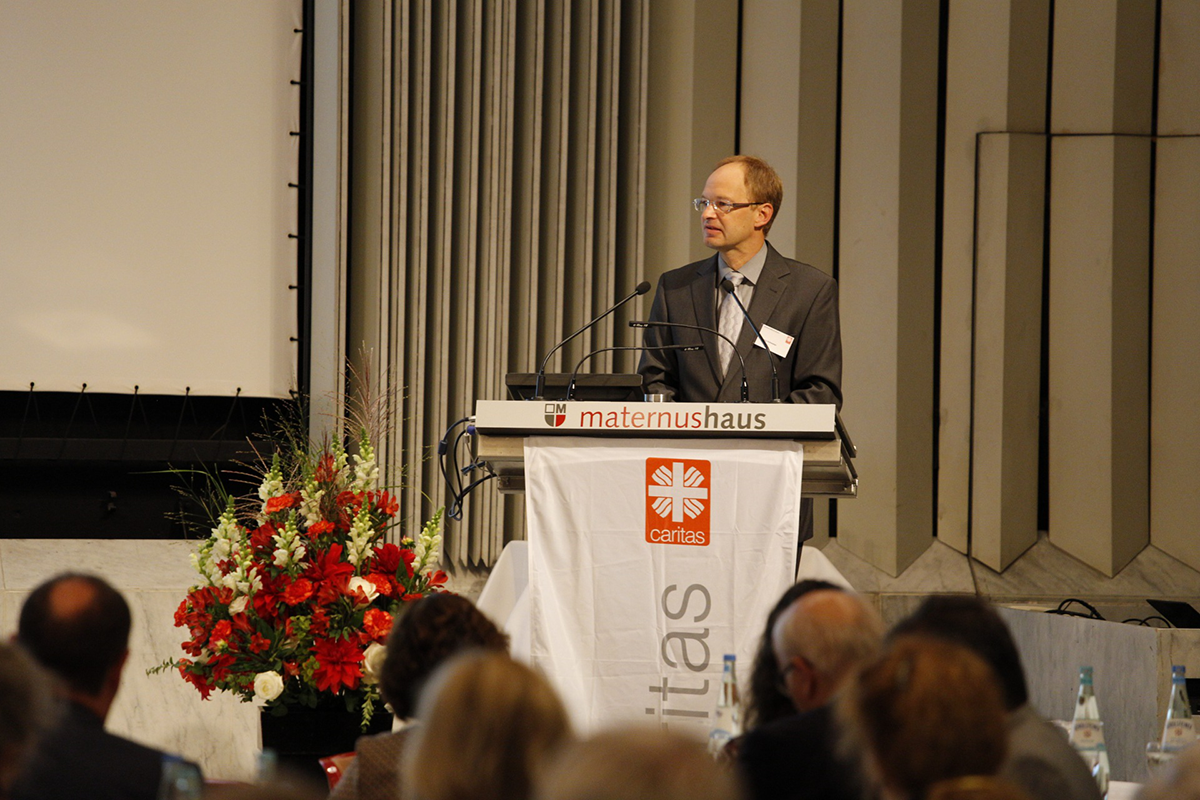 Dr. Georg Hofmeister steht beim Fachforum 'Von der Kunst, ein christliches Unternehmen zu führen' vor einem Pult und hält eine Begrüßungsrede (Martin Karski)
