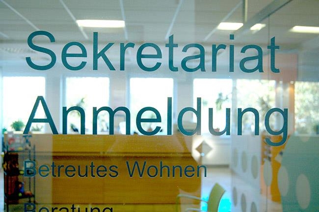 Glasscheibe im Innenbereich mit Beschriftung Sekretariat Anmeldung  (Caritasverband Darmstadt e. V.)