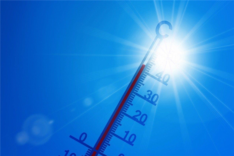 Sonne von blauem Himmel, Thermometer zeigt über 30 Grad