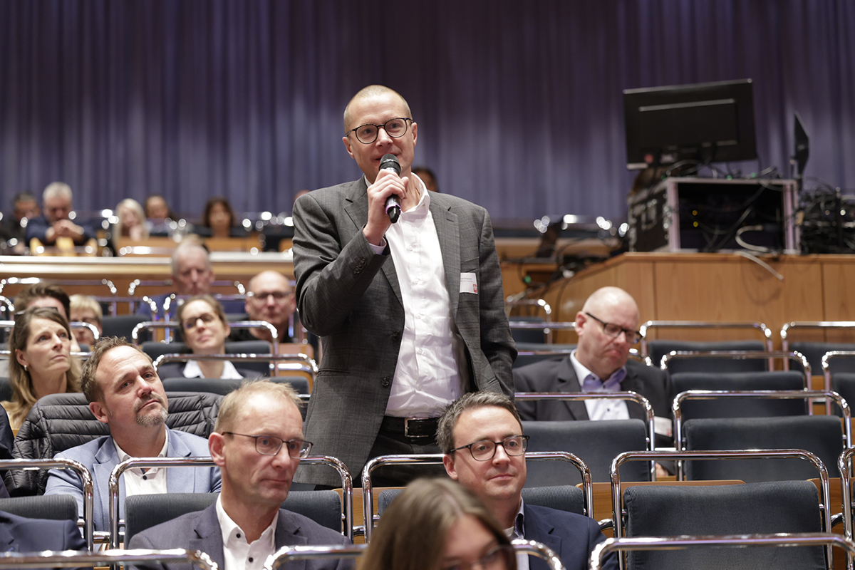 Dr. Conrad Middendorf (Geschäftsführer des St. Irmgardis-Krankenhaus Süchteln) steht beim 2. Kath. Krankenhaustag am 21.11.2023 in Essen im Publikum und stellt eine Frage (Foto: Achim Pohl)