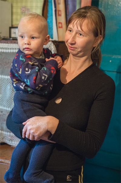 Eine Mutter hält stehend ihren kleinen Sohn auf dem Arm (Achim Pohl)
