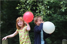 ein Mädchen und ein Junge mit zwei Luftballons / KNA / Oppitz