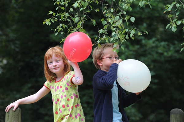 ein Mädchen und ein Junge mit zwei Luftballons