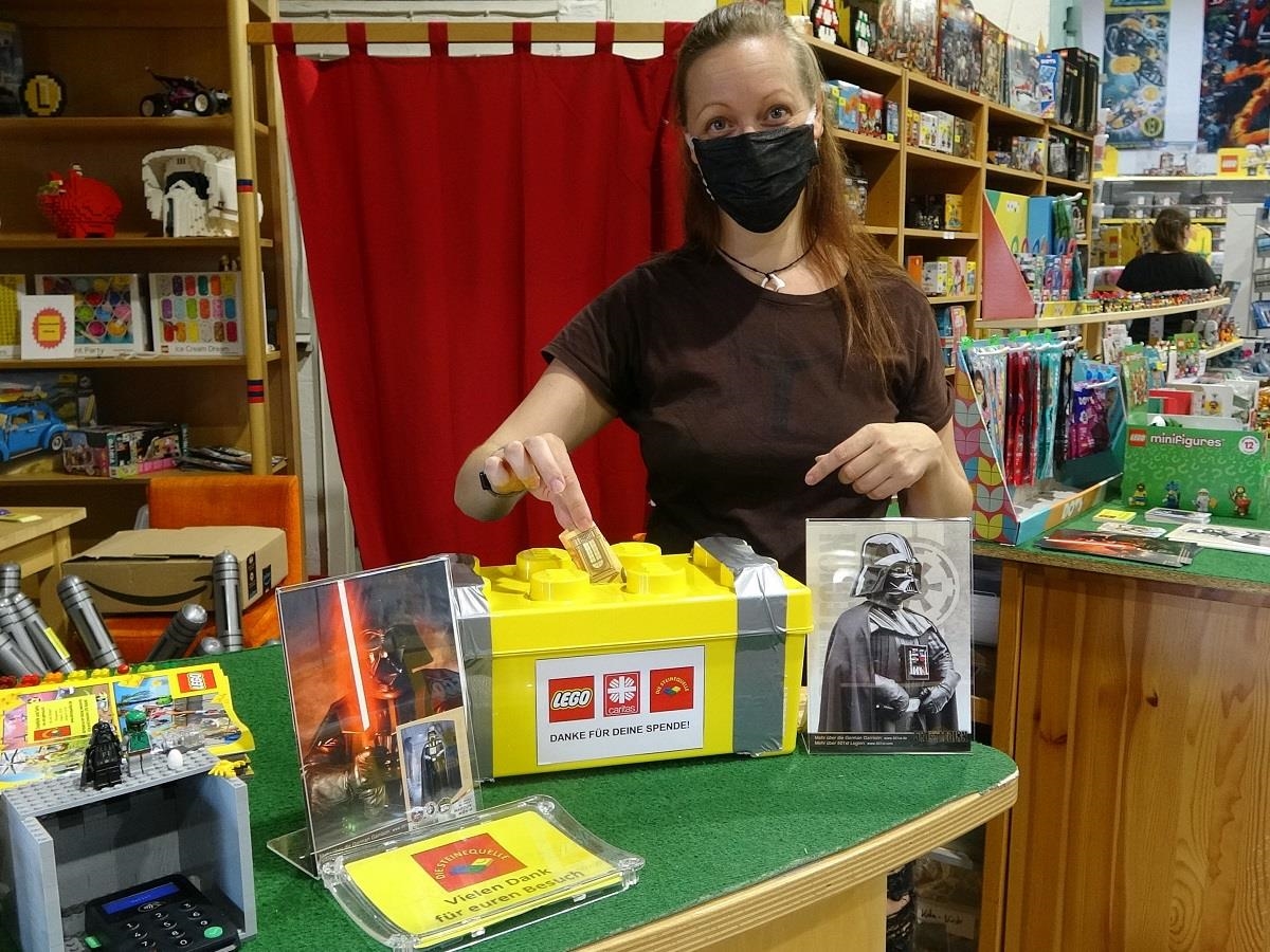Eine Besucherin wirft Geld in die Spendenbox im Lego-Store. (Uwe Schumann)