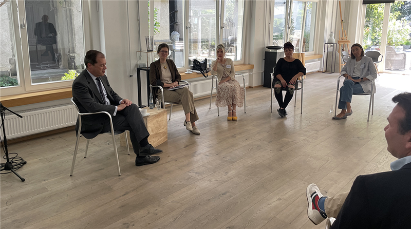 Teilnehmende einer Gesprächsrunde beim Besuch von NRW-Europastaatssekretär Dr. Marks Speich im Zentrum Kukuna in Wuppertal, die zusammen in einem Stuhlkreis sitzen