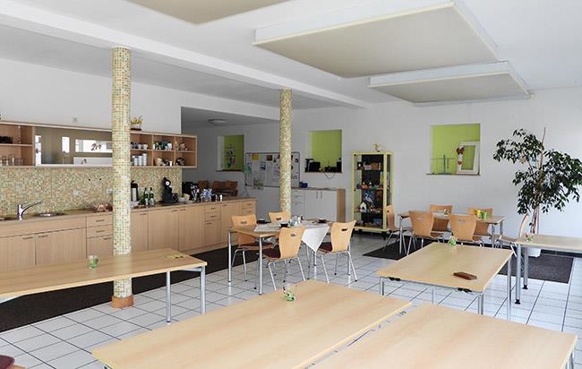 Großaufnahme des Cafés, sechs große Tische sind zu erkennen (Caritasverband Darmstadt e. V. / Jens Berger)