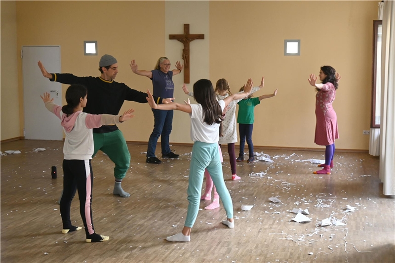 Der Tänzer Marco Jodes, Petra Kollmar (Gemeindereferentin der Pfarrei Vorderhunsrück St. Hildegard) und Bühnenbildnerin Manuela Pirozzi tanzen gemeinsam mit den Kindern.