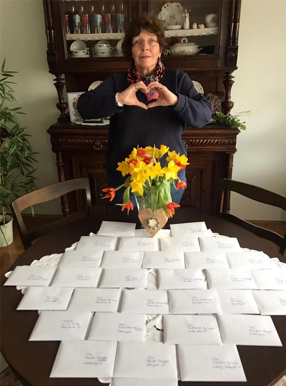 eine freundliche Frau mit einen Strauß Blumen und vielen Briefen (privat)