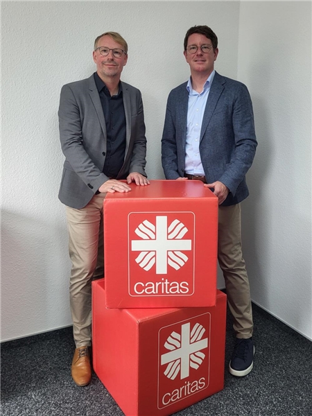 Die zwei Caritas-Vorstände Thomas Hanschen und Michael Kreuzfelder mit Caritas-Würfeln.