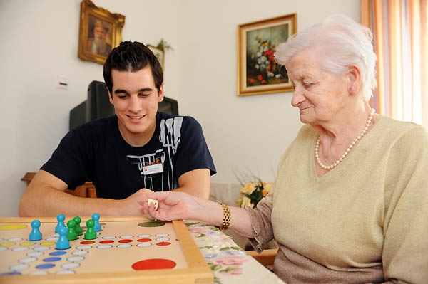 alte Dame mit jungem Mann bei einem Brettspiel