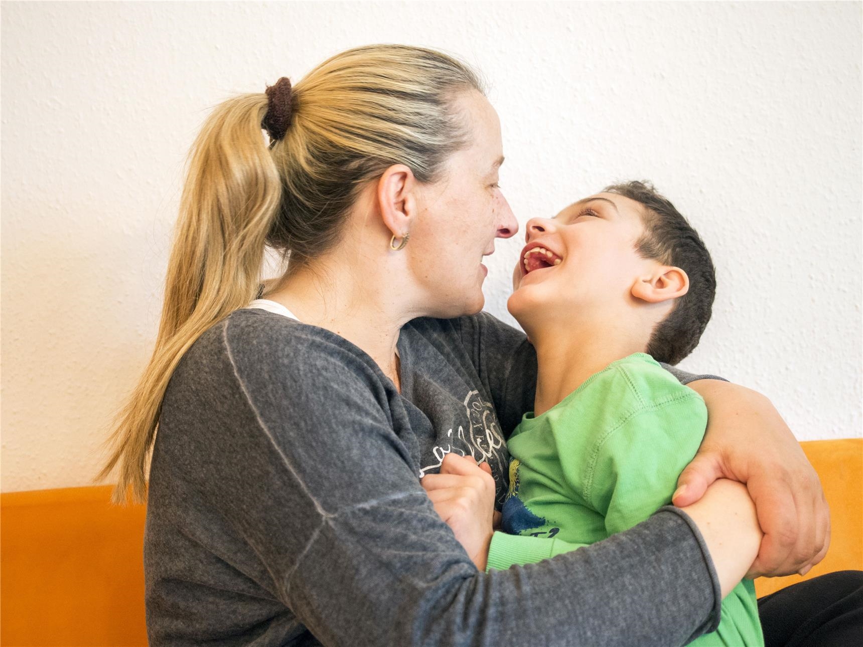 Behinderter Junge in liebevoller Umarmung mit seiner Mutter (Angela Kröll)