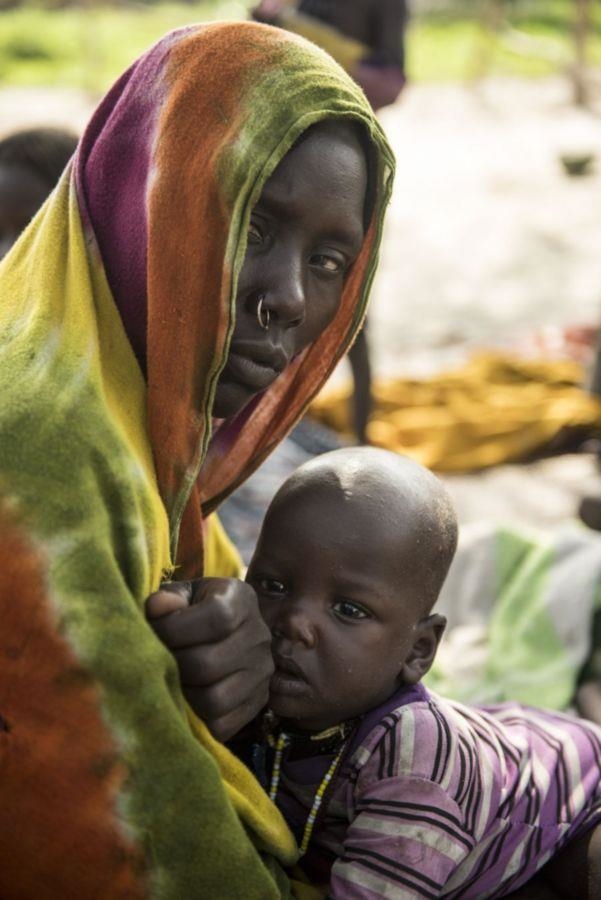 Eine Frau mit einem Baby schaut traurig in die Kamera (Michael Stulman, CRS)