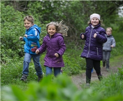 Zwei Mädchen und ein Junge laufen einen Waldweg herunter / Dietmar Wäsche