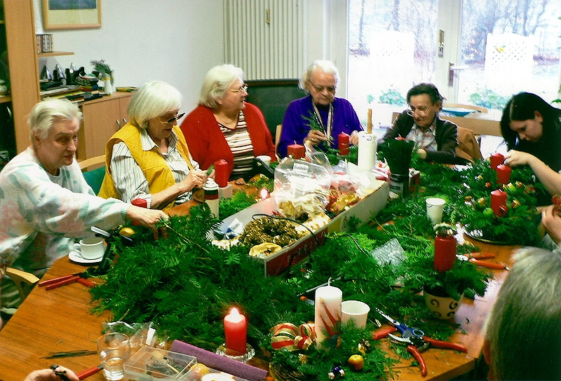 Weihnachtliches Basteln mit Tannengrün in froher Tischrunde. 