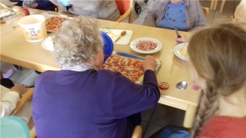 Seniorin am Tisch mit Pizza