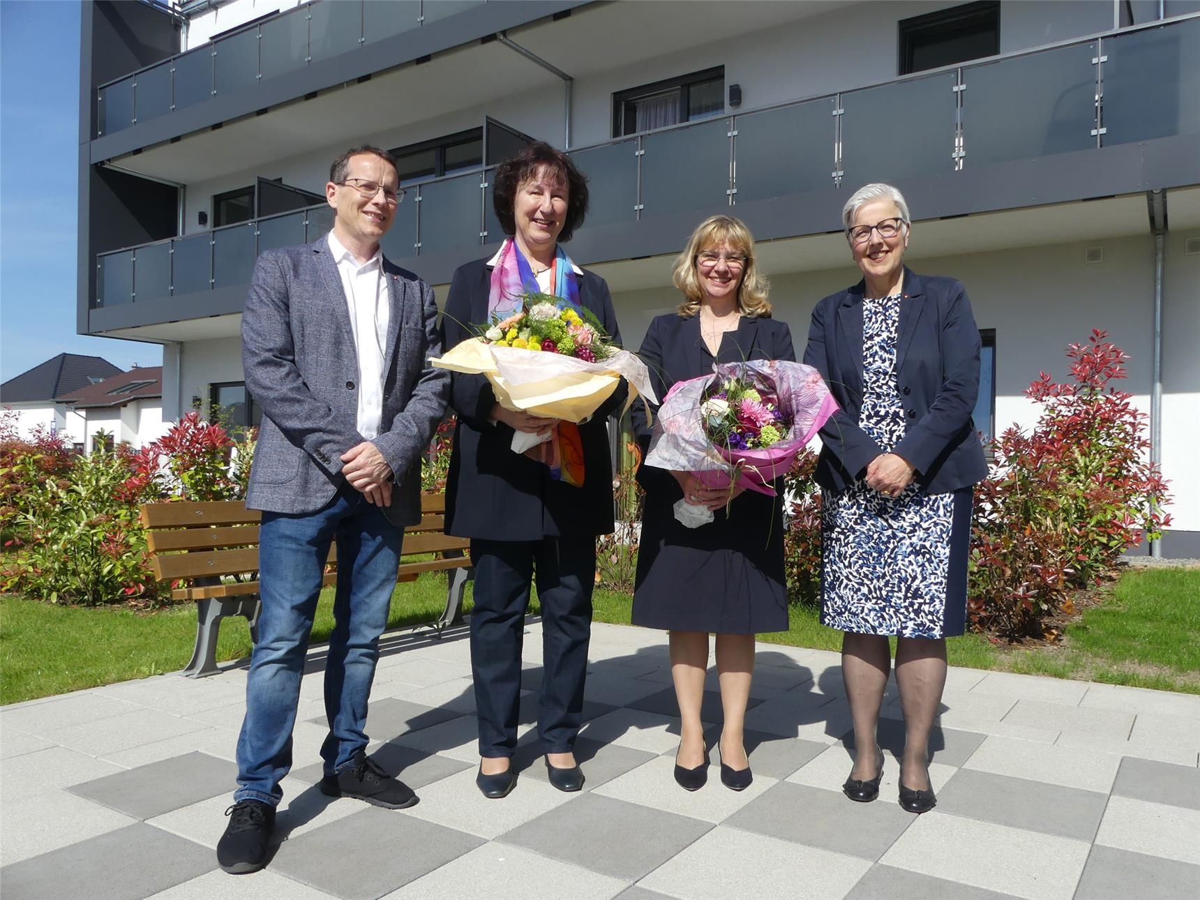 Gruppenbild mit vier Personen: Blumen vom Vorstand für die neue und die scheidender Bereichsleiterin für Beratungsdienste im Kreis Offenbach