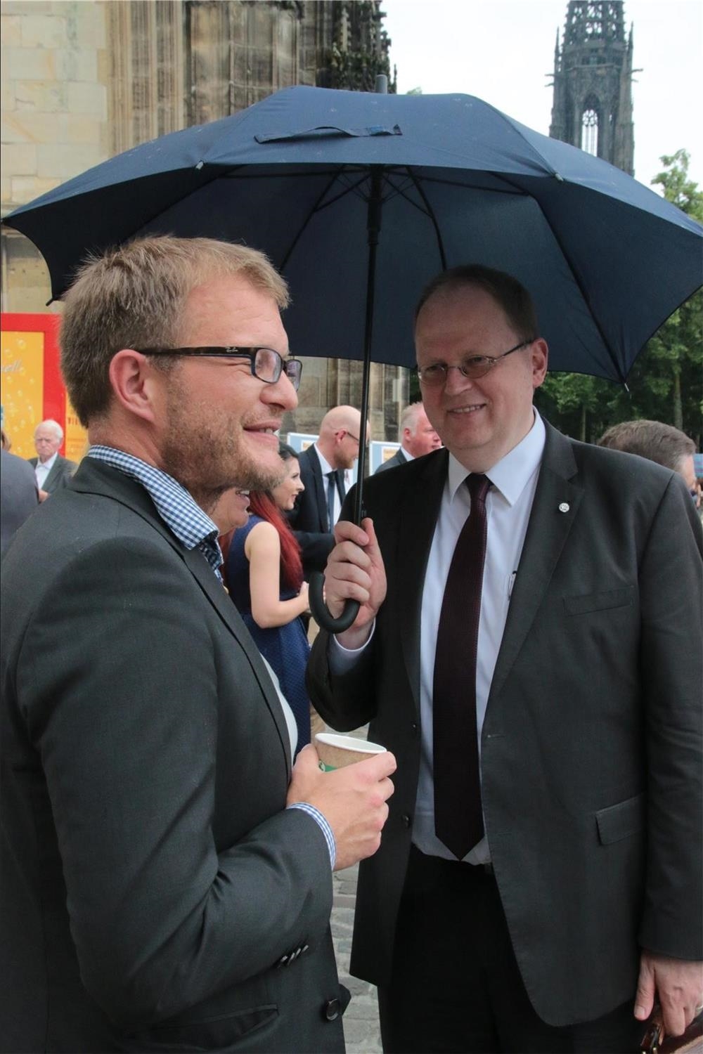 Das Foto zeigt zwei Männer, einer davon mit Schirm. (Harald Westbeld)