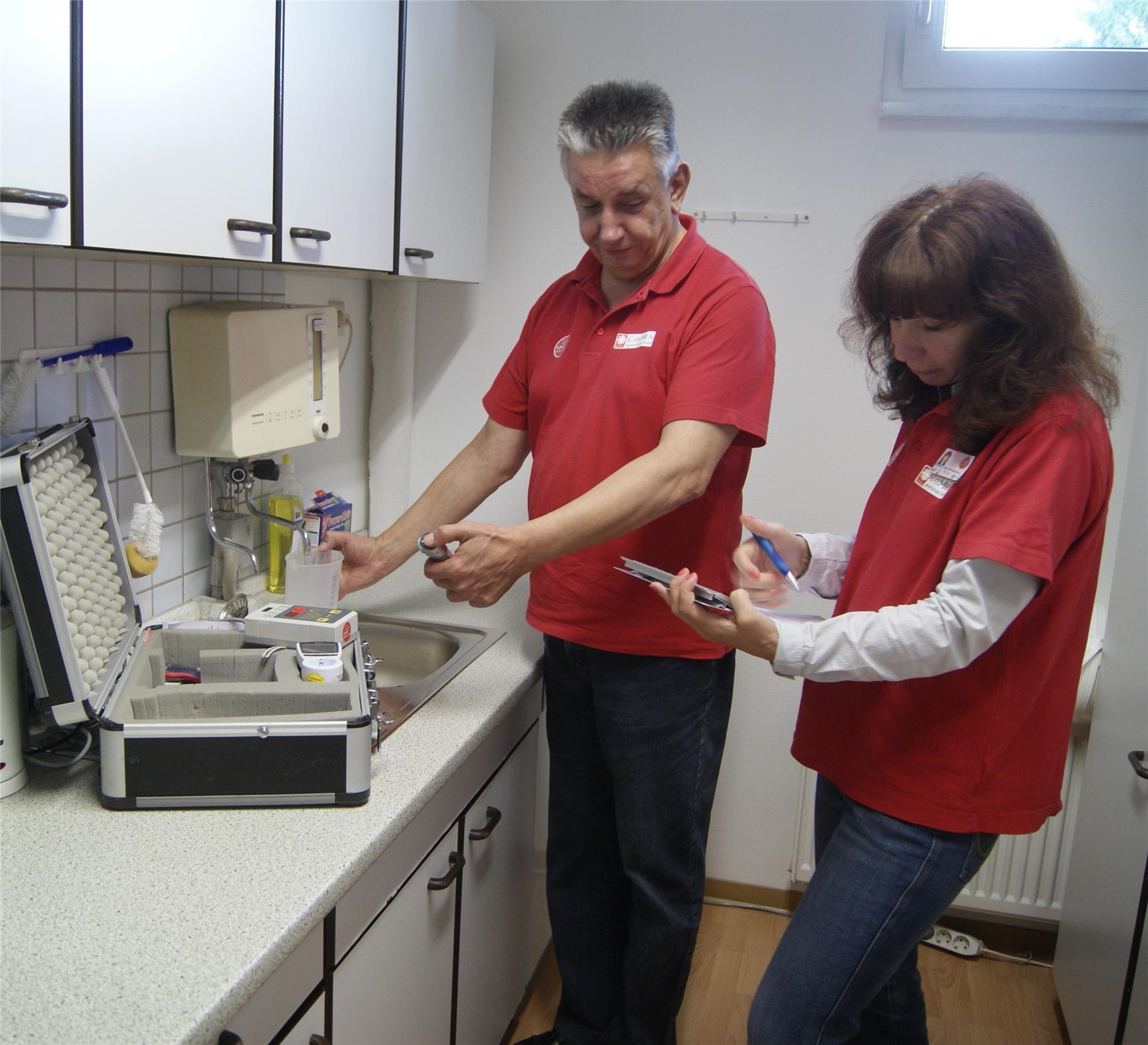 Zwei Caritas-Mitarbeiter in der Küche beim Stromsparcheck (Foto: Marco Wagner)