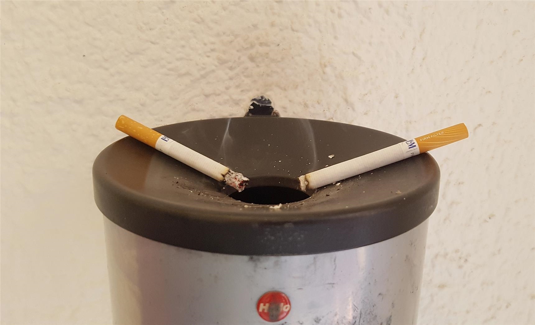 Das Foto zeigt zwei brennende Zigaretten, von denen der blaue Dunst, Rauch, aufsteigt. 