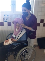 Pflegerin mit Mundschutz frisiert Bewohnerin / Foto: Caritashaus St. Vincenz