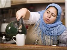 Frau mit Kopftuch gießt Kaffee ein