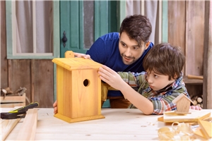 Vater und Sohn bauen gemeinsam einen Nistkasten für Vögel